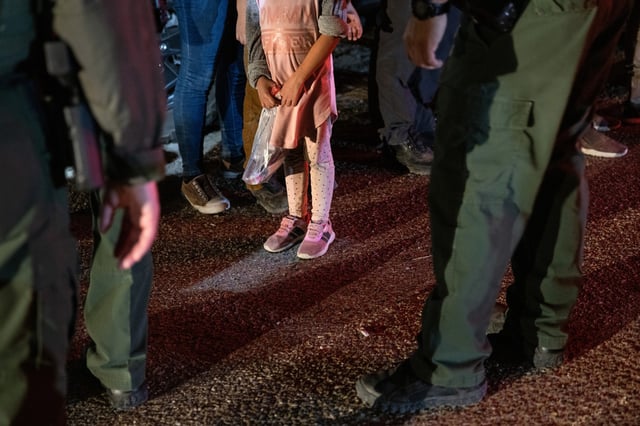 U.S. Border Patrol agents speak to an unaccompanied minor from Honduras, 4,  after she crossed the Rio Grande from Mexico, in Roma, Texas, on Aug. 14, 2021.
