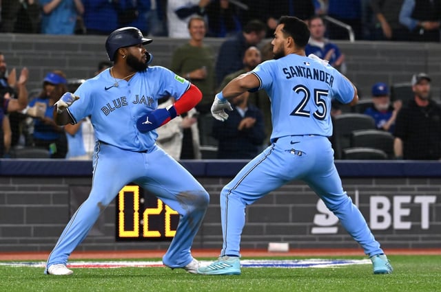 Toronto Blue Jays' Vladimir Guerrero Jr, left, and Anthony Santander (25) celebrate after Santander hit a three-run home run against the Boston Red Sox in seventh inning American League baseball action in Toronto on Wednesday, April 30, 2025. THE CANADIAN PRESS/Jon Blacker