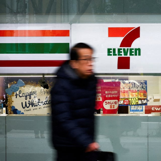 A man walks past the logo of 7-Eleven displayed at their convenience store in Tokyo, March 6, 2025.