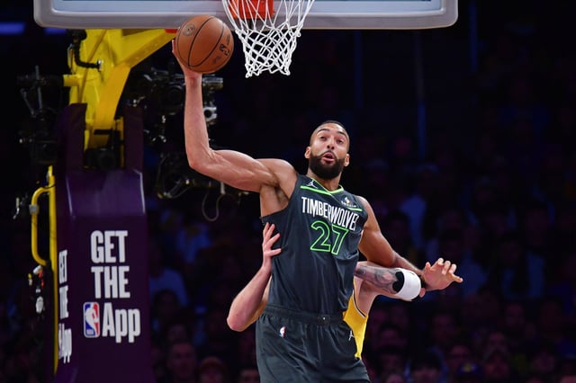 Apr 30, 2025; Los Angeles, California, USA; Minnesota Timberwolves center Rudy Gobert (27) gets the ball against Los Angeles Lakers guard Luka Doncic (77) during the first half in game five of first round for the 2025 NBA Playoffs at Crypto.com Arena. Mandatory Credit: Gary A. Vasquez-Imagn Images