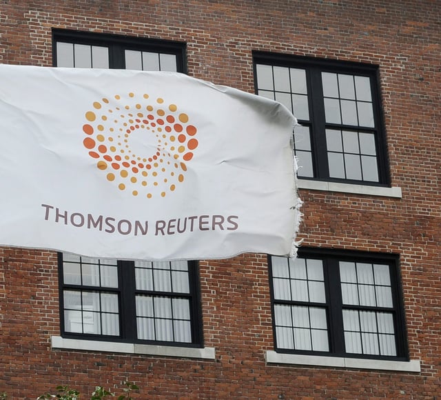 Thomson Reuters says its profit fell in its latest quarter as revenues edged higher. A flag displaying the Thomson Reuters logo flies outside a company building, Monday, Aug. 11, 2008 in Boston. (AP Photo/Lisa Poole)