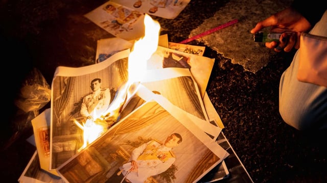 A protester burns portraits of King Vajiralongkorn during a demonstration demanding the release of alleged offenders of Thailand’s lèse majesté law (Sipa photo by Varuth Pongsapipatt via AP Images).