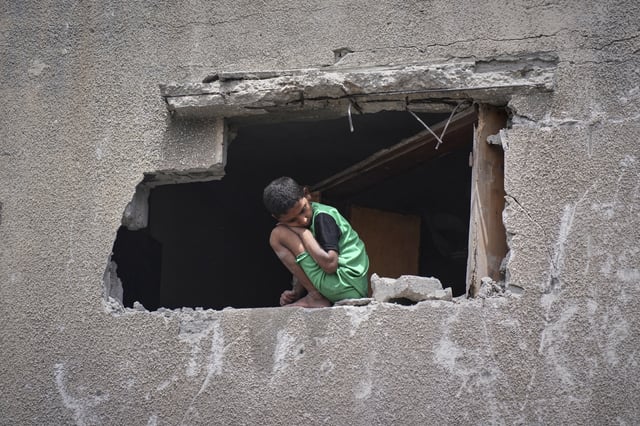 A boy looks as Palestinians search the rubble of a house targeted by an Israeli army strike that killed at least five people in Khan Younis, in the southern Gaza Strip, on Thursday, May 1, 2025. (AP Photo/Abdel Kareem Hana)