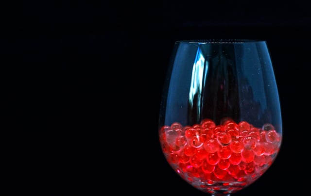 Red jelly balls in wine glass.