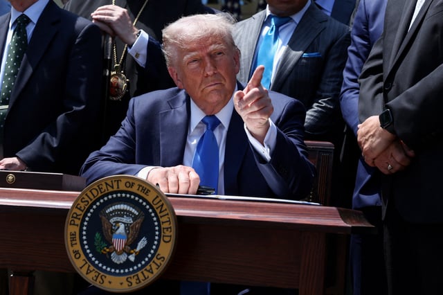 U.S. President Donald Trump points, surrounded by faith leaders, during an executive order signing ceremony on the National Day of Prayer, in the Rose Garden at the White House in Washington, D.C., U.S., May 1, 2025. REUTERS/Evelyn Hockstein/File Photo