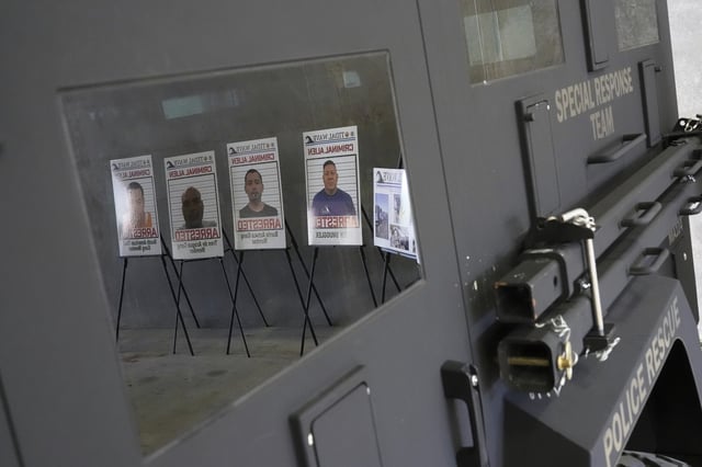 Posters of alleged criminals who officials said were arrested in a recent immigration enforcement operation are reflected in a Department of Homeland Security vehicle during a press conference with Gov. Ron DeSantis at the South Florida office of U.S. Immigration and Customs Enforcement and Enforcement and Removal Operations, Thursday, May 1, 2025, in Miramar, Florida.