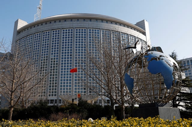 A Chinese flag flutters near a globe installation outside the Chinese foreign ministry in Beijing, China February 24, 2022. REUTERS/Carlos Garcia Rawlins/File Photo