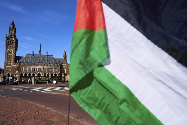 A Palestinian flag flies outside the International Court of Justice, rear, which opened hearings into a United Nations request for an advisory opinion on Israel's obligations to allow humanitarian assistance in Gaza and the West Bank, in The Hague, Netherlands, Monday, April 28, 2025. (AP Photo/Peter Dejong)