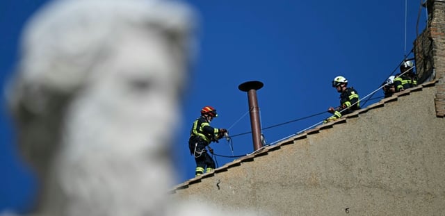 Des pompiers installent une cheminée sur le toit de la Chapelle Sixtine, au Vatican, quelques jours avant le début du conclave, le 2 mai 2025