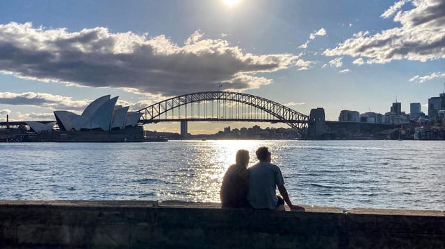 Ein Pärchen blickt auf die Harbour Bridge und die Oper in Sydney.