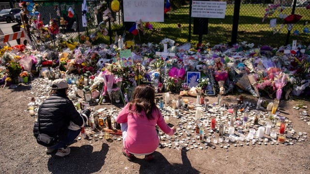 People are pictured at one of the many memorials to the victims of the Lapu-Lapu Day festival tragedy on May 1, 2025. The B.C. government has declared Friday a day of mourning for the victims in the car-ramming that killed 11 people and injured dozens more.