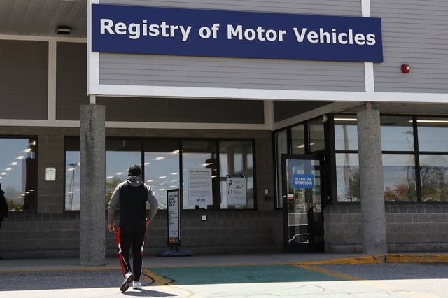 FILE - A man walks to the Commonwealth of Massachusetts Registry of Motor Vehicles office in Lawrence, Mass., May 5, 2020. (AP Photo/Charles Krupa, File)