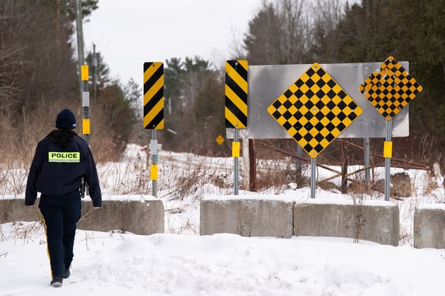 A Royal Canadian Mounted Police (RCMP) officer checks  the border between Quebec and New York State on Roxham Road in St. Bernard-de-Lacolle, Que. on Wednesday, Jan.15, 2025. THE CANADIAN PRESS/Christinne Muschi