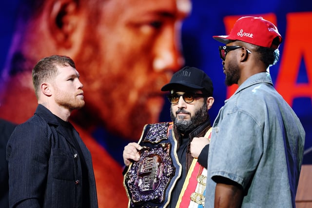 Canelo Alvarez of Mexico faces off with William Scull of Cuba as chairman of Saudi Arabia's General Entertainment Authority Turki Alalshikh holds the belts during a press conference.
