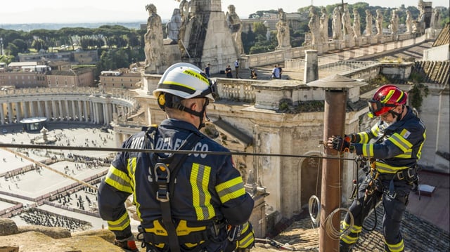 Dieses vom Vatikan veröffentlichte Bild zeigt Feuerwehrmänner, die den Schornstein für das Konklave auf der Sixtinischen Kapelle montieren