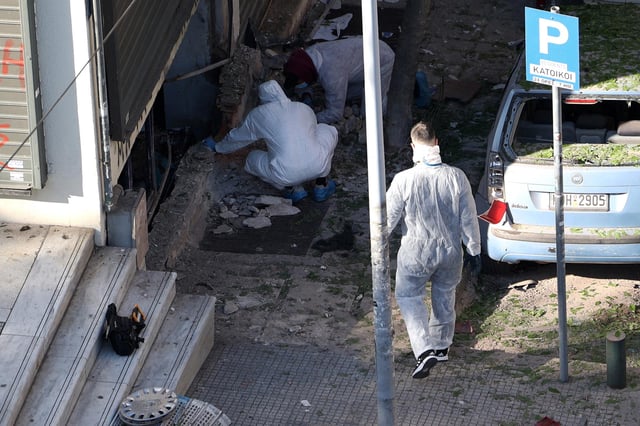 Forensics officers investigate the area of a blast caused by an explosive device outside a bank that killed a 38-year old woman in Thessaloniki, Greece on May 3.