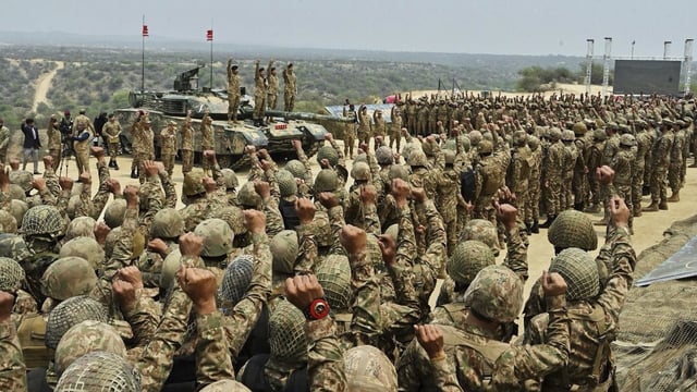 Pakistan's Army Chief Asim Munir, second left standing on tank, chant 'long live Pakistan' slogans with soldiers during his visit to witness military exercises, in Tilla Field Firing Range in the Jhelum district.