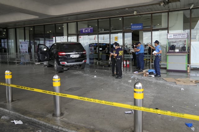 First responders work the scene after a vehicle drove into a departures entrance at Manila's International Airport, in Manila, Philippines, Sunday, May 4, 2025. (AP Photo/Aaron Favila)