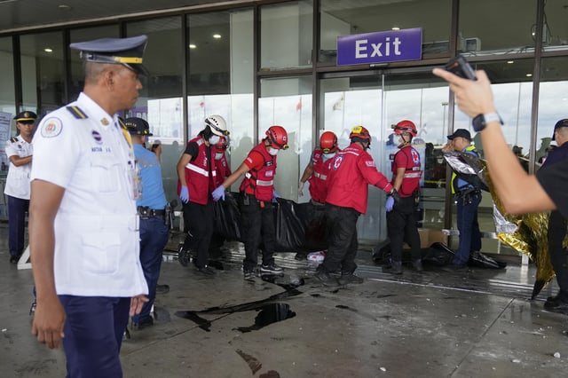 Rescuers carry a body of a victim after a vehicle drove into a departures entrance at Manila's International Airport terminal 1, in Manila, Philippines, Sunday, May 4, 2025. (AP Photo/Aaron Favila)
