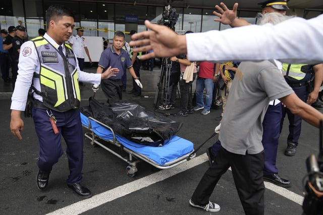 First responders bring the body of a victim after a vehicle drove near the departure entrance at Manila's International Airport Terminal 1, killing some people while injuring others in Manila, Philippines on Sunday, May 4, 2025. (AP Photo/Aaron Favila)