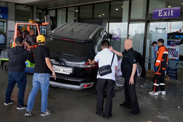 Airport authorities help first responders after a driver crashed an SUV into the entrance at Manila's International Airport Terminal 1 in Manila, Philippines, on Sunday, May 4, 2025.