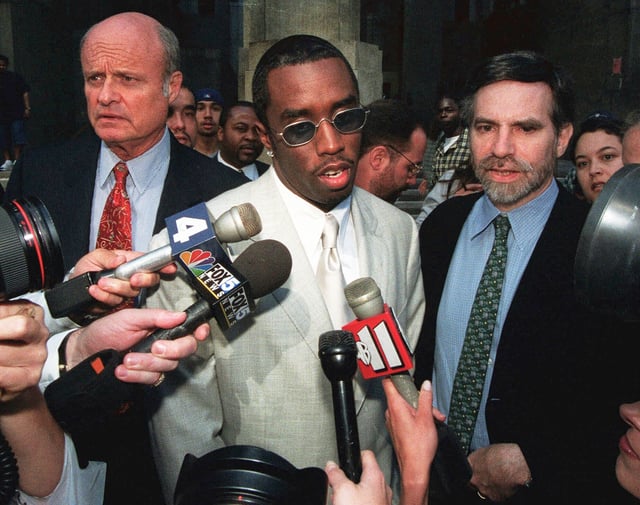 FILE - Rapper Sean "Puffy" Combs, center, speaks to the media outside of court in New York after his assault case was postponed on June 24, 1999. (AP Photo/Lynsey Addario, File)
