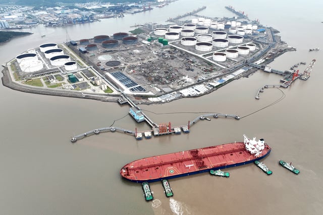 An aerial view shows tugboats helping a crude oil tanker to berth at an oil terminal, off Waidiao Island in Zhoushan, Zhejiang province, China July 18, 2022. cnsphoto via REUTERS/File Photo