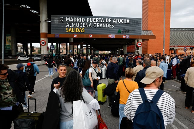 Passengers wait to be given access to their trains after cable stolen from a high-speed train line between Madrid and Andalusia caused delays at Atocha station in Madrid, Spain, May 5, 2025. REUTERS/Susana Vera