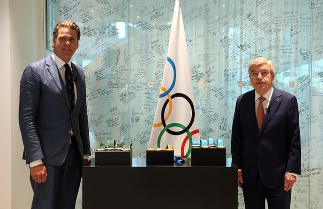 IOC President Thomas Bach presents American swimmer Gary Hall Jr. replicas of his ten Olympic medals that he lost during the wildfires in Los Angeles that destroyed his home earlier this year during a ceremony at the Olympic House in Lausanne, Switzerland, May 5, 2025. REUTERS/Denis Balibouse/Pool