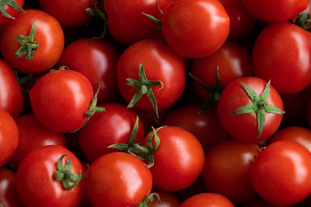Ripe red cherry tomatoes at a retail market or hypermarket. Vegetarian, vegan and raw food and diet. Organic homemade farm products. Harvesting in the garden, vegetable garden, in the country. Food background. From the farm to the table. Vegetable food.
