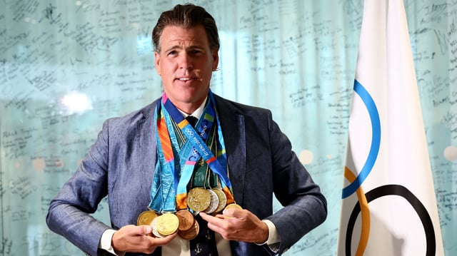 US swimmer Gary Hall Jr. (L) poses wearing the replica Olympic medals that the IOC president to him during a handover ceremony after the originals were destroyed with his house in the Los Angeles wildfires earlier this year, at the Olympic House in Lausanne on May 5, 2025.