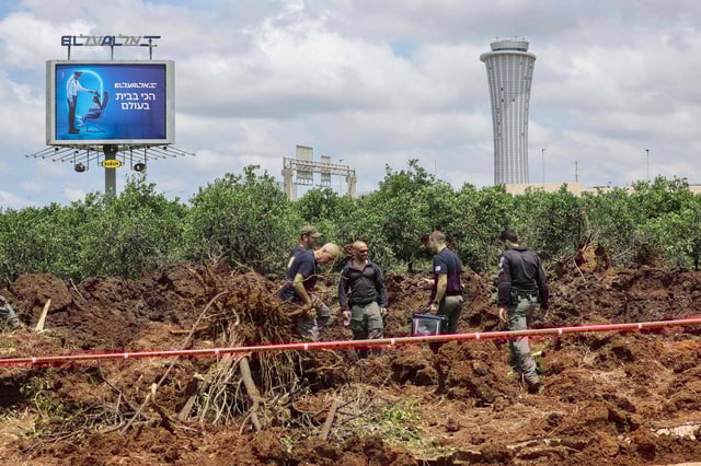 Des membres des services de sécurité israéliens à l'extérieur de l'aéroport israélien Ben Gurion après qu'un missile lancé depuis le Yémen ait frappé la zone le 4 mai 2025.