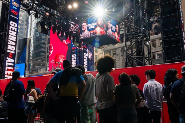 People gather around a fenced-in boxing ring in Times Square on May 2, 2025 in New York City. (Photo by Spencer Platt/Getty Images)