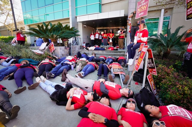 Members from the National Union of Healthcare Workers (NUHW) stage a “die-in” at the front entrance to the Kaiser Administration Office on Tuesday, March 25, 2025, in San Diego, CA.  (Nelvin C. Cepeda / The San Diego Union-Tribune)