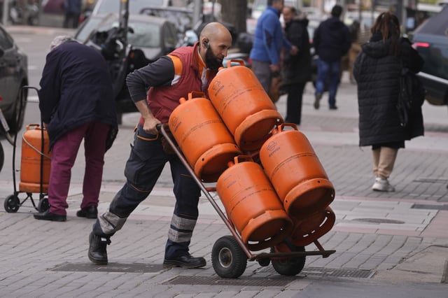 FILE -A worker delivers butane gas bottles in Madrid, Spain, Monday, March 28, 2022. (AP Photo/Paul White, File)