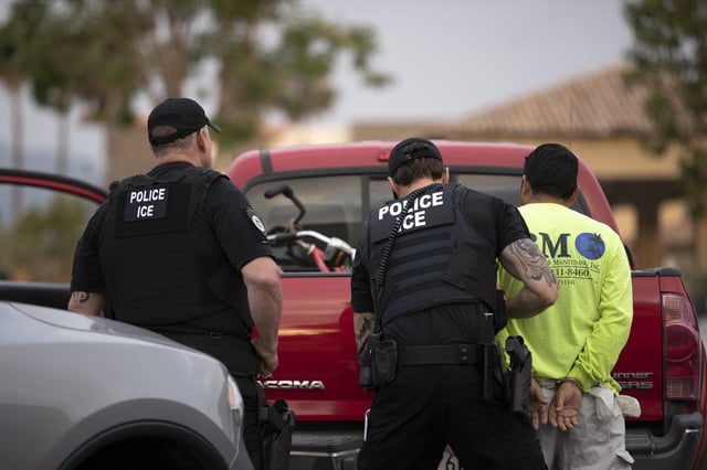 In this July 8, 2019, photo, a U.S. Immigration and Customs Enforcement (ICE) officers detain a man during an operation in Escondido, Calif.