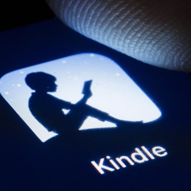 The logo of Amazon E-Book reader Kindle is shown on the display of a smartphone