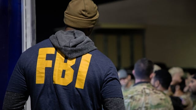 An FBI agent listens to the operation pre-briefing for Operation Dead Hand. As part of this investigation, a team of FBI and international law enforcement agencies conducted multiple arrests the morning of January 30, 2024, across the United States and Canada, to disrupt and dismantle an international organized crime syndicate importing and exporting massive quantities of drugs across the North American continent.