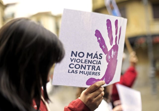 Una mujer sujeta una pancarta contra la violencia de género.