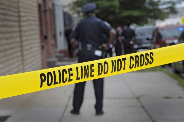 Thumbnail Image; General Crime and Police; Crime, Courts,  Law Enforcement  Baltimore City | Baltimore, MD -- 06/01/2012 -- A Baltimore Police officer stands behind crime scene tape at the scene of a police-involved shooting following a dispatch for a burglary in progress, reported near S. Chester Street and Bank Street in southeast Baltimore Friday, Jun 1, 2012. A suspect was shot, while another was taken into custody as investigators pore through evidence. (Karl Merton Ferron/Baltimore Sun Staff) [POLICE INVOLVED SHOOTING (_1D32583.JPG)]