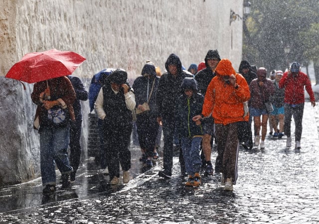 Personas caminando bajo la lluvia.