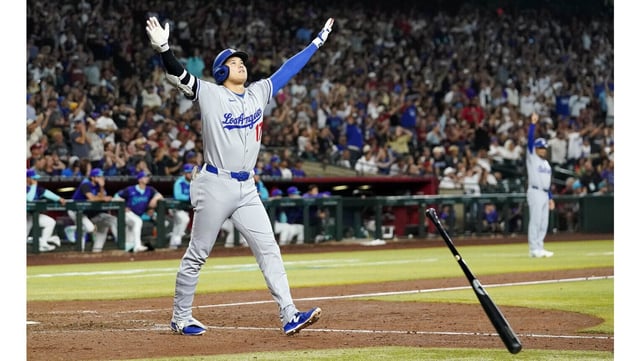 Dodgers star Shohei Ohtani tosses his bat as he begins to celebrate after hitting a tiebreaking three-run home run during the ninth inning of their game against for the Arizona Diamondbacks on Friday night in Phoenix. (AP Photo/Darryl Webb)