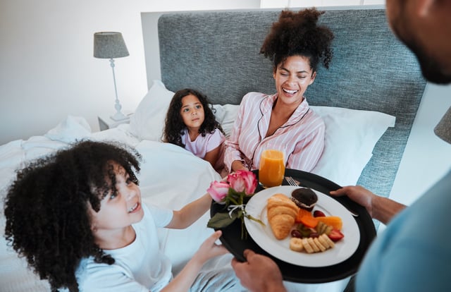 A stock photo shows a mother being presented with breakfast in bed. Multiple chain locations are offering food deals this Mother&#39;s Day 2025.