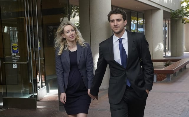 Former Theranos CEO Elizabeth Holmes, left, walks with her partner, Billy Evans, after leaving federal court in San Jose, Calif., Monday, Oct. 17, 2022. (AP Photo/Jeff Chiu)