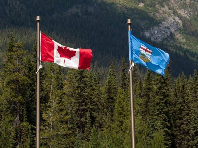  Flags of Alberta and Canada flutter in the wind.