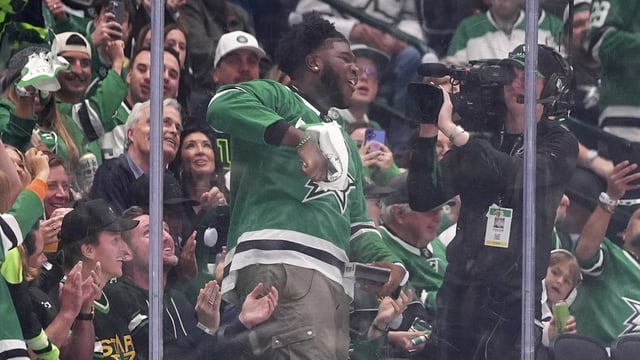 Tyler Booker, center, the Dallas Cowboys first-round NFL football draft pick, cheers the Dallas Stars in the second period of Game 3 of a second-round NHL hockey playoff series against the Winnipeg Jets in Dallas, Sunday, May 11, 2025. (AP Photo/Julio Cortez)