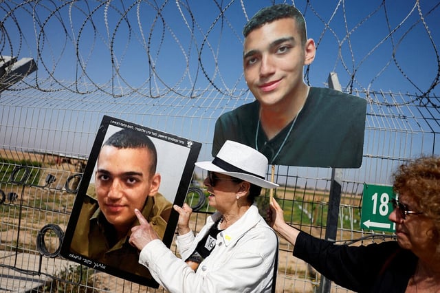 Eine Frau mit weißem Hut hält ein Foto der amerikanischen Hamas-Geisel Edan Alexander
