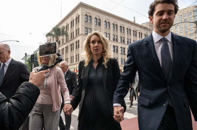 Elizabeth Holmes (C), founder and former CEO of blood testing and life sciences company Theranos, walks with her mother Noel Holmes and partner Billy Evans into the federal courthouse for her sentencing hearing on November 18, 2022 in San Jose, California. – Holmes faces sentencing after being found guilty of defrauding investors and endangering patients in a case that became an indictment of Silicon Valley. US federal prosecutors are seeking a 15-year jail term for Holmes and want her to pay $800 million in restitution to investors. (Photo by Amy Osborne / AFP) (Photo by AMY OSBORNE/AFP via Getty Images)