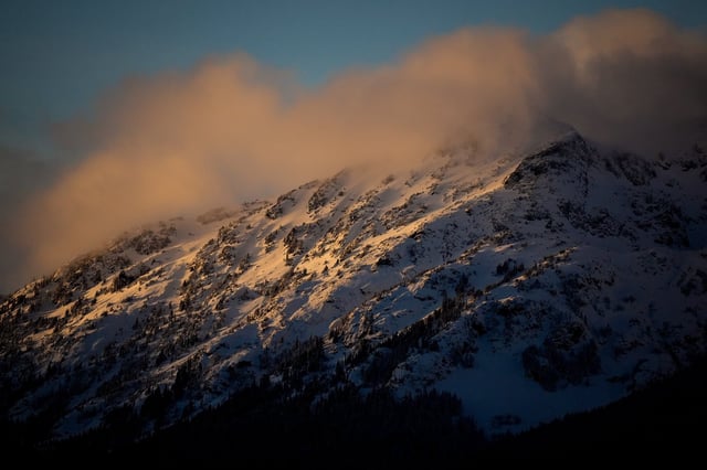 The setting sun shines on the snow-covered top of Rainbow Mountain, in Whistler, B.C., on Friday, November 25, 2022. THE CANADIAN PRESS/Darryl Dyck