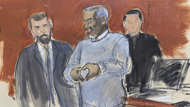 Sean Diddy Combs, center, motions a heart sign to his family in attendance as he is escorted out of lock-up by US Marshals, on the first day of trial, Monday, May 12, 2025, in New York.